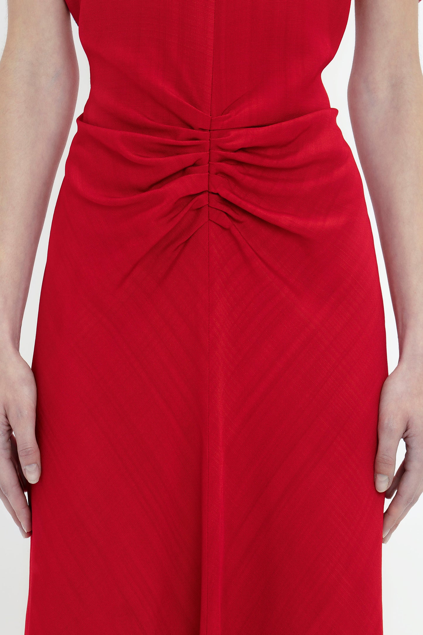 Close-up of a woman in a Victoria Beckham Exclusive Gathered V-Neck Midi Dress In Carmine, focusing on the detailed ruching at the back.