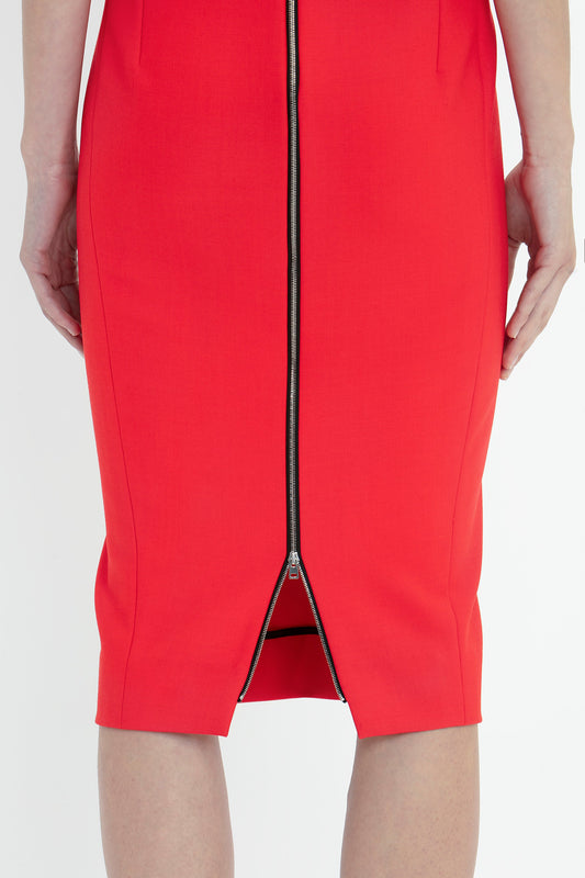 Close-up view of the lower part of a Victoria Beckham Sleeveless Fitted T-Shirt Dress In Bright Red with a frontal zipper, showing detail from the waist to the knees against a white background.