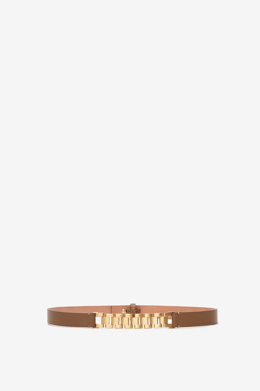 A tan calf-leather "Watch Strap Detail Belt in Khaki-Brown" by Victoria Beckham featuring a gold-toned metal buckle with geometric detailing, centered on a plain white background.