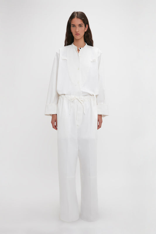 A woman in a Drawstring Pyjama Trouser In Washed White by Victoria Beckham standing against a plain background.