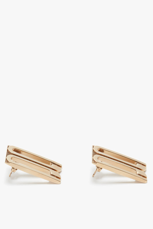 Two Exclusive Frame Stud Earrings In Gold by Victoria Beckham displayed against a white background.