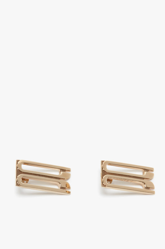 Two Victoria Beckham Exclusive Frame Stud Earrings In Gold isolated on a white background.
