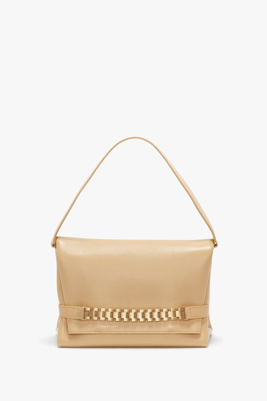 A Chain Pouch With Strap In Sesame Leather from Victoria Beckham, with a distinctive gold chain detail on the bottom, displayed against a white background.