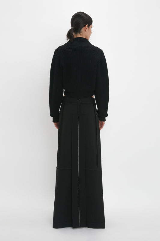 A woman in a Victoria Beckham black Cropped V-Neck Cardigan.