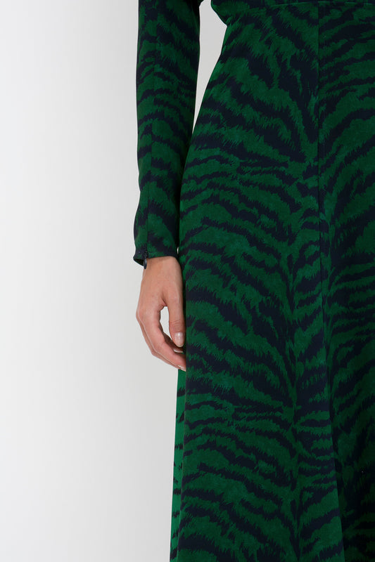 Close-up of a person wearing a Victoria Beckham Dolman Midi Dress In Green-Navy Tiger Print, focusing on the midsection and arm.