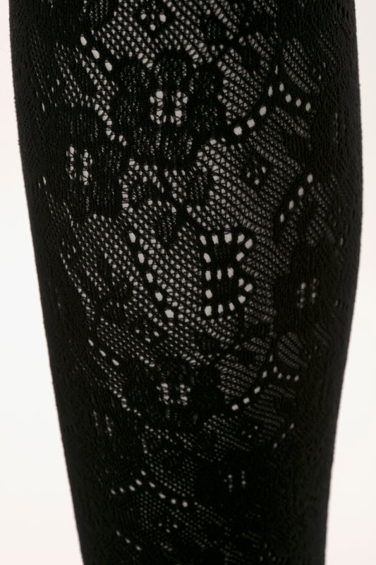 Close-up view of Victoria Beckham's Exclusive VB Monogram Lace Tights In Black showcasing intricate floral patterns, made with denier-40 threading for seamless and sag-free construction.