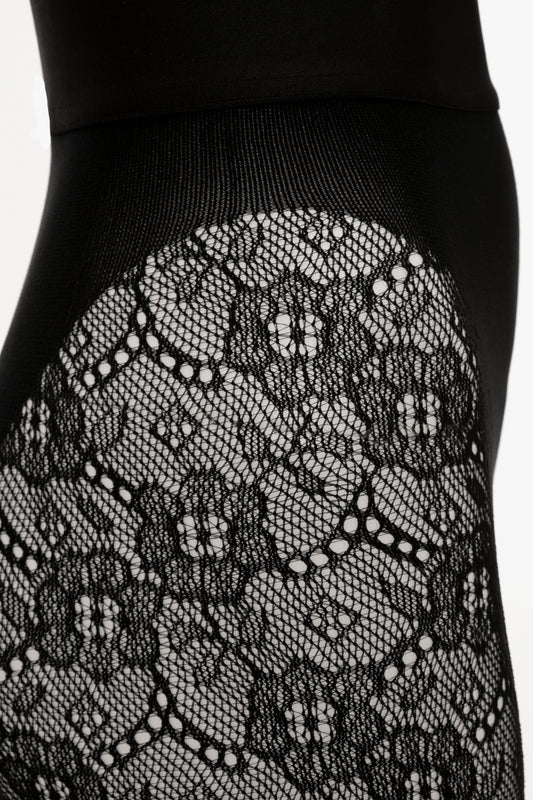 Close-up of black Exclusive VB Monogram Lace Tights fabric with floral patterns on a garment featuring seamless and sag-free construction by Victoria Beckham.