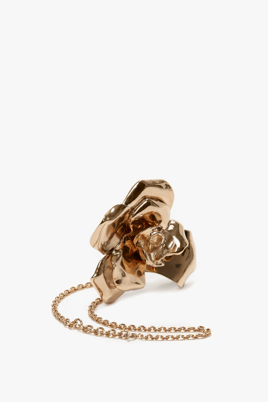 Victoria Beckham exclusive flower bracelet in gold brushed brass crumpled flower-shaped pendant with an adjustable chain on a white background.