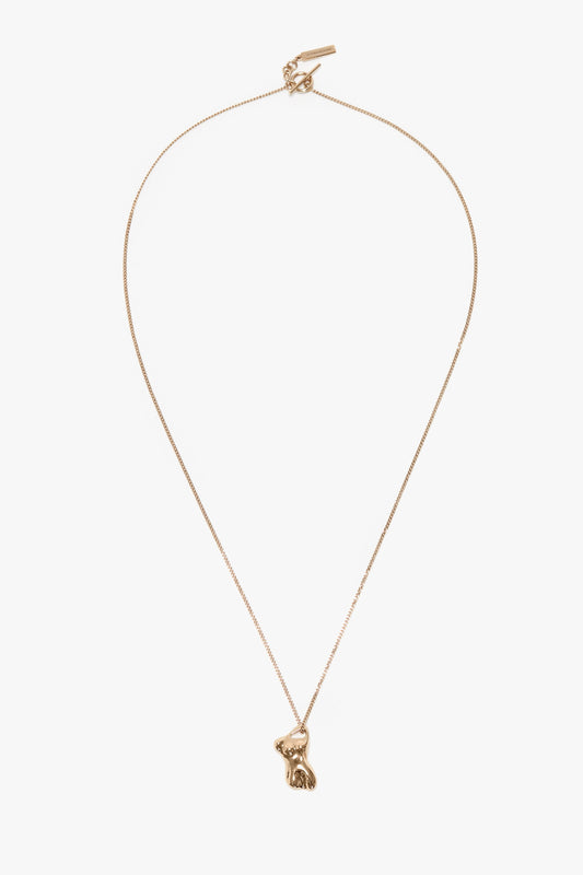 A light gold necklace featuring a delicate chain and a 100% brass pendant shaped like a sitting rabbit, this Exclusive Body Charm Necklace In Light Gold by Victoria Beckham is an exquisite accessory.