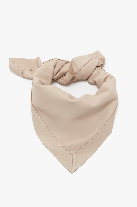Victoria Beckham taupe silk scarf tied in a heart shape on a white background.