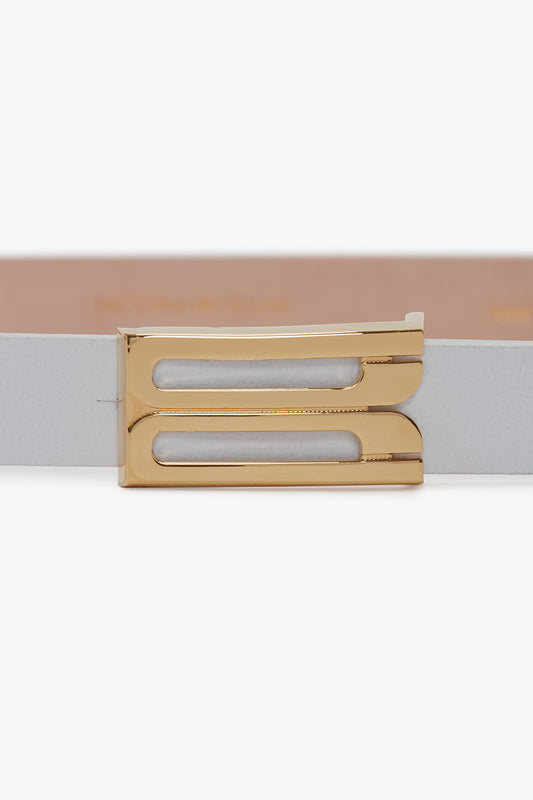 A close-up of a beige Victoria Beckham Exclusive Micro Frame Belt In White Leather with a gold rectangular buckle.