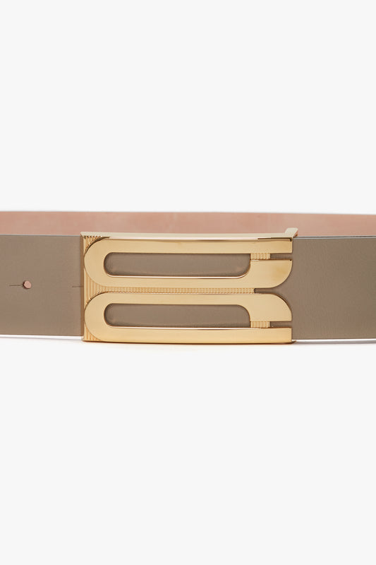 Close-up of a modern Victoria Beckham exclusive jumbo frame belt in beige leather featuring sleek, gold hardware.