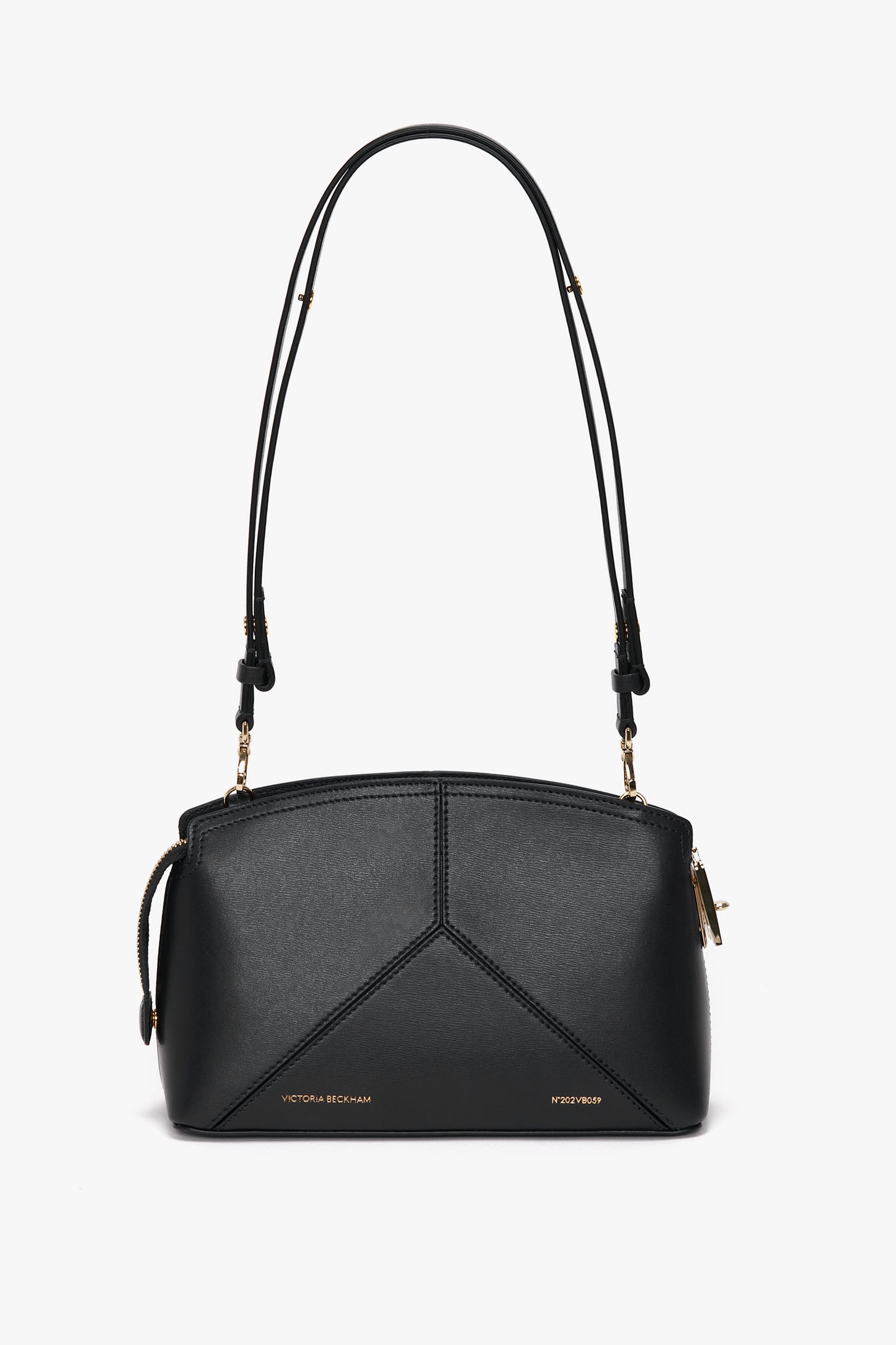 The Victoria Beckham Victoria Crossbody Bag In Black Leather is crafted from textured calf leather in black, accented with gold hardware and an adjustable strap. The front features subtle branding.