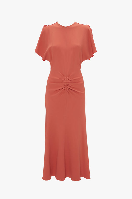 Victoria Beckham's Gathered Waist Midi Dress In Papaya with short sleeves and a twisted knot detail at the waist, featuring a flared hem, displayed on a white background.