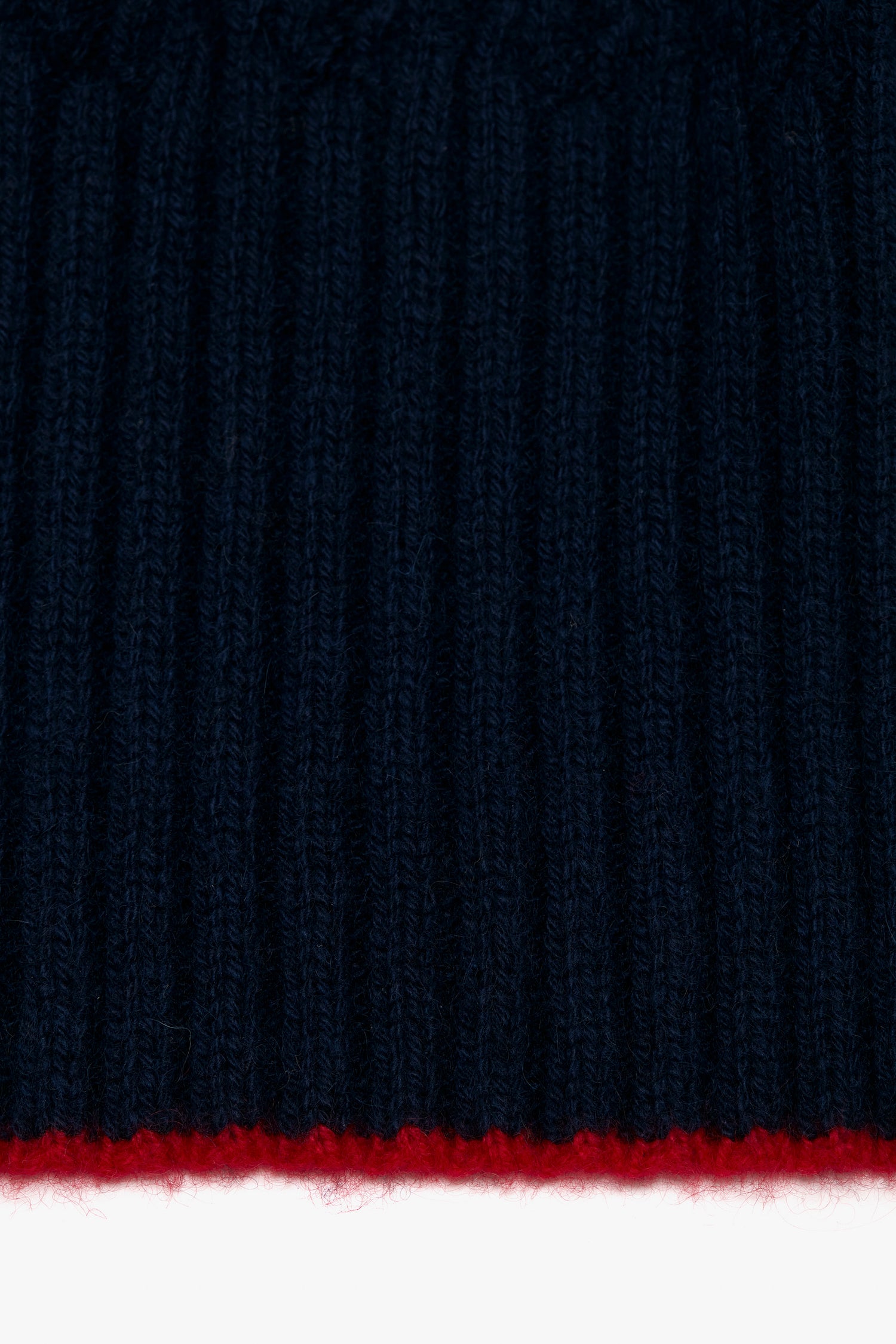 Close-up of a navy Exclusive Logo Patch scarf with a thin red stripe at the bottom and a Victoria Beckham logo patch.