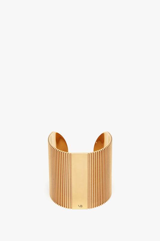 Victoria Beckham's Exclusive Perfume Cuff In Gold cuff bracelet with a vertical ribbed design on a plain white background.