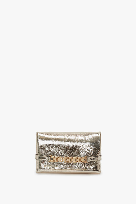 A gold leather Mini Chain Pouch with long strap from Victoria Beckham, featuring a decorative buckle and strap detail, displayed against a plain white background.