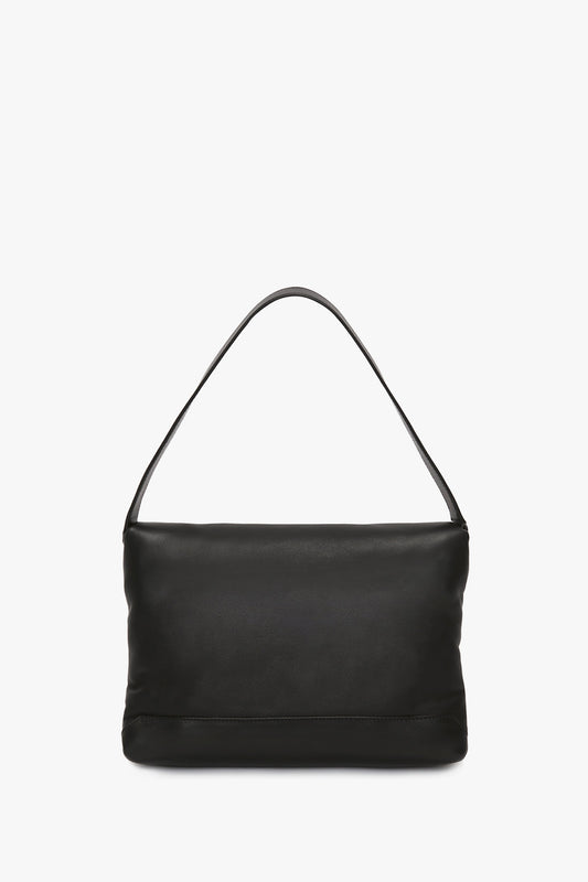 Puffy Chain Pouch With Strap In Black Leather shoulder bag with a rectangular base and a single strap, displayed against a white background by Victoria Beckham.