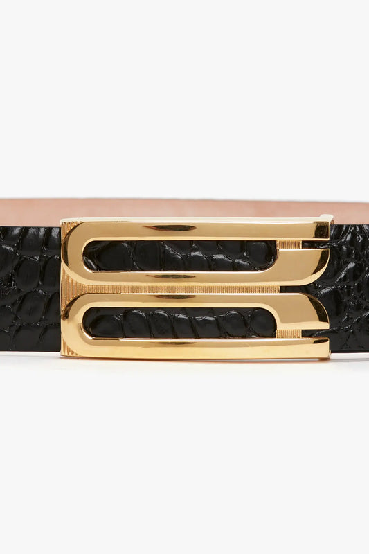 A close-up view of a Victoria Beckham Jumbo Frame Belt in Black Croc-Effect Leather with a shiny gold double-g buckle on a white background.