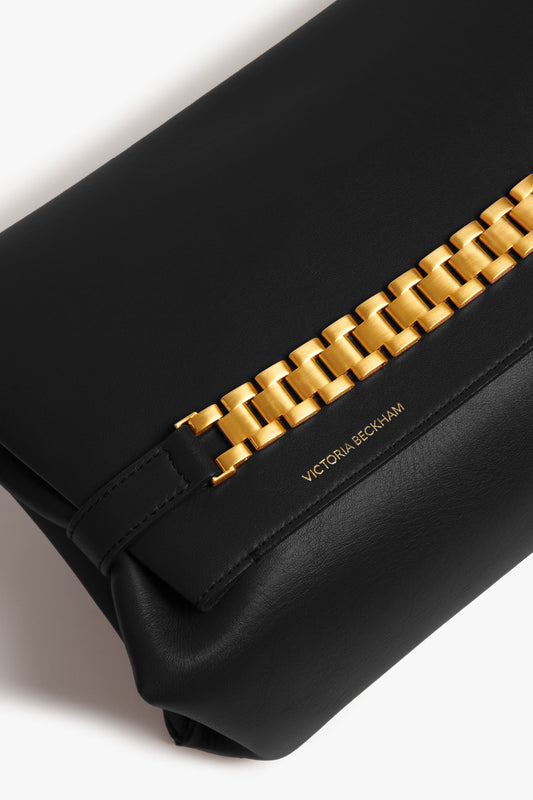 Close-up of a black Victoria Beckham Chain Pouch Bag with prominent gold-tone hardware.