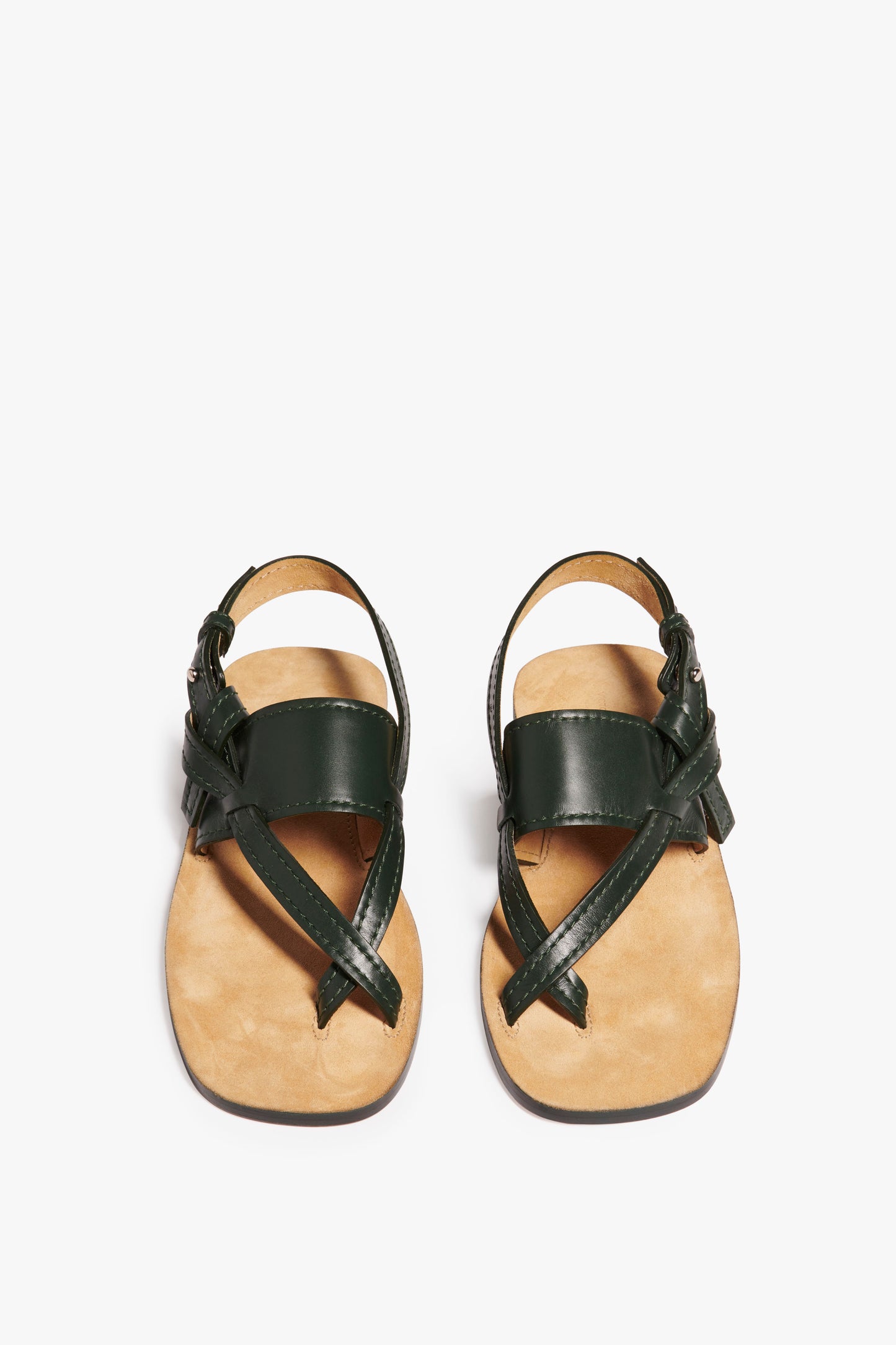 A pair of the Victoria Beckham Eve Flat Sandal in Bottle Green featuring a bottle green hue and tan soles, placed side by side on a plain white background.