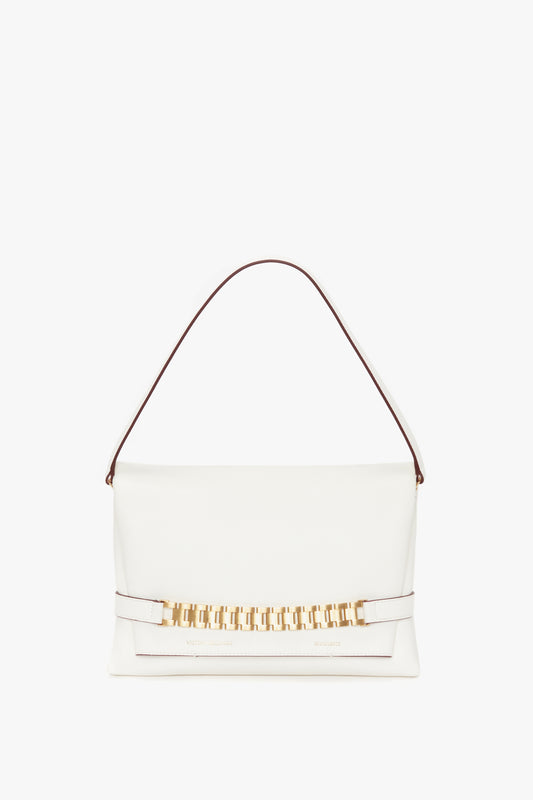 A white Victoria Beckham Nappa leather Chain Pouch with Strap with a gold clasp and a brown handle isolated on a white background.