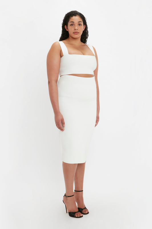 A woman in a white VB Body Strap Bandeau Top stands against a plain background, wearing black heeled sandals.