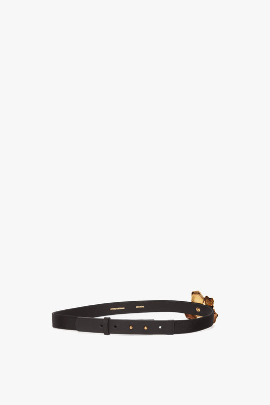 Exclusive Flower Belt in Black and Gold by Victoria Beckham, with a gold-plated buckle featuring sculptural floral designs, isolated on a white background.