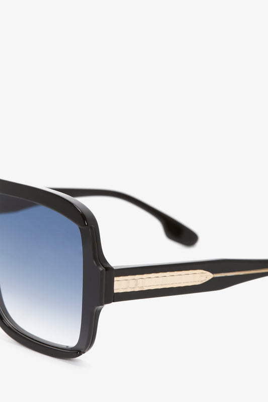 Layered Mask Sunglasses In Black Gradient by Victoria Beckham, with blue tinted lenses and patterned temples, isolated on a white background.