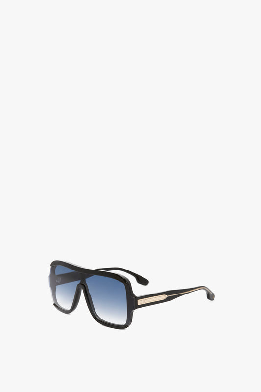 A pair of Victoria Beckham Layered Mask Sunglasses In Black Gradient with a gold accent on the arms, isolated on a white background.