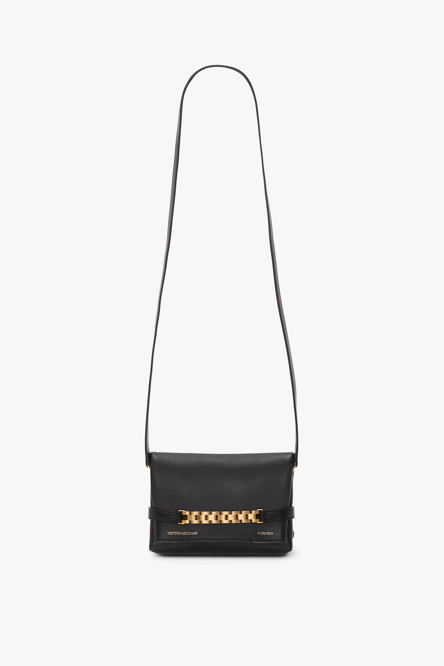 A Mini Chain Pouch Bag With Long Strap In Black Leather in luxurious black lambskin leather, featuring a long strap and a gold-tone watch strap detail on the front flap by Victoria Beckham.