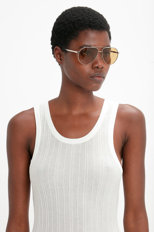 A woman wearing Victoria Beckham V Metal Pilot Sunglasses In Silver-Brown and a tank top.