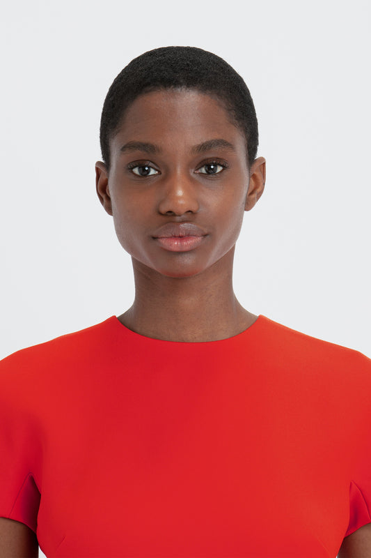 A woman in a Victoria Beckham fitted T-shirt dress in bright red.