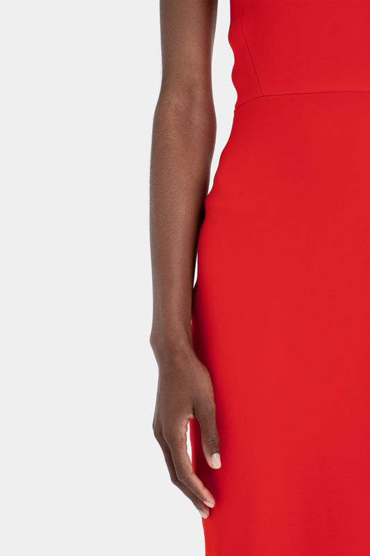 Close-up of a woman's arm by her side, wearing a Victoria Beckham Fitted T-shirt Dress in Bright Red, set against a white background.