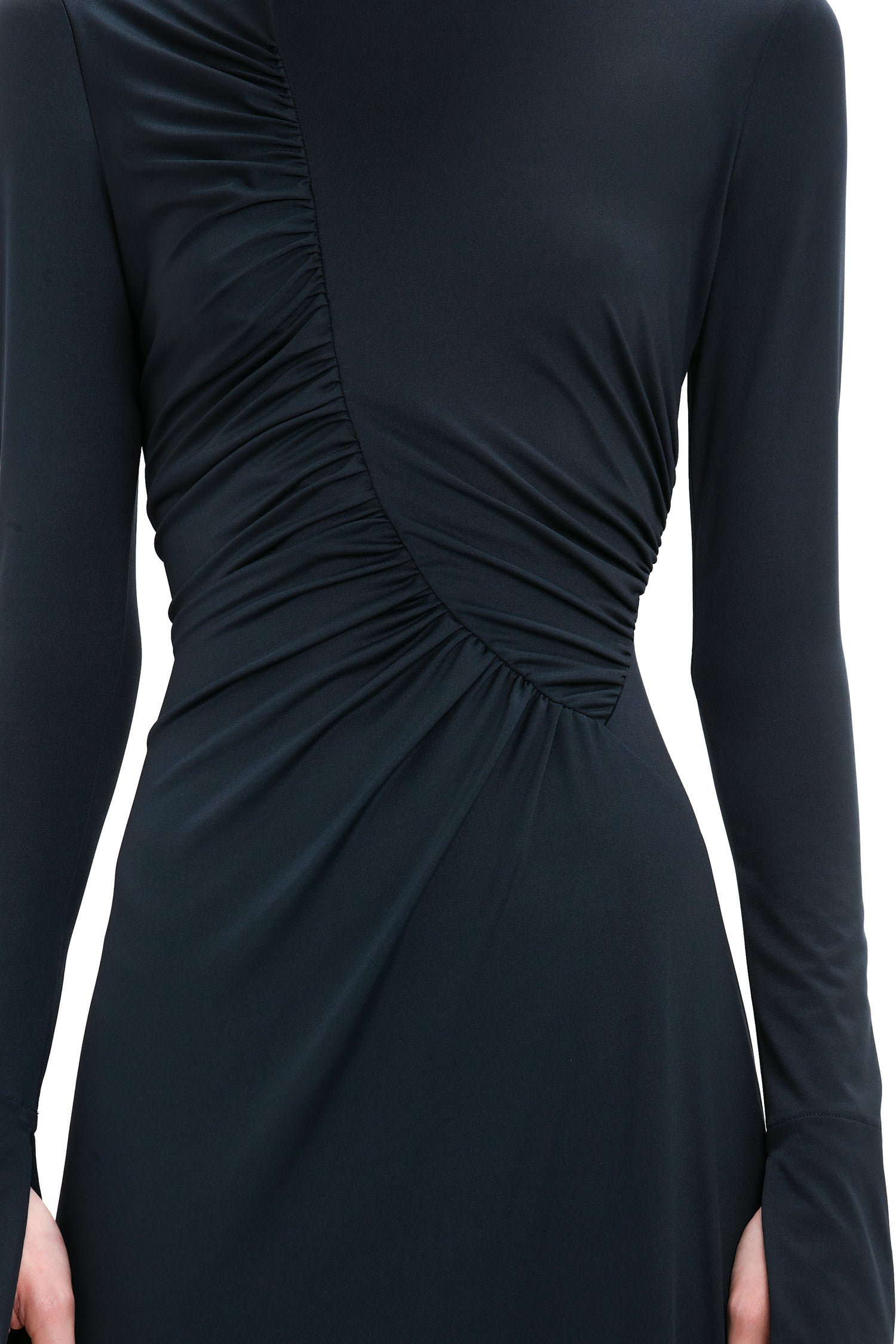 Close-up of a person wearing a navy blue, long-sleeve dress with an asymmetrical ruched design across the chest and waist, reminiscent of a sophisticated Victoria Beckham Ruched Detail Floor-Length Gown In Midnight.