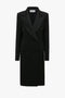 The Victoria Beckham Double Breasted Tuxedo Coat in Black crafted from lightweight wool gabardine, featuring wide lapels and two front pockets, delivers a modern relaxed feel against a white background.