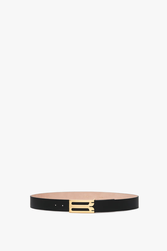 An Exclusive Jumbo Frame Belt In Navy Leather by Victoria Beckham boasts a sophisticated rectangular buckle with gold hardware, all beautifully presented on a white background.