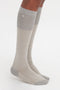 A person wearing knee-high, Superfine Rib Socks In Lunar Grey by Victoria Beckham made of 100% cotton with reinforced heels and toes, stands on a white background.