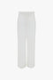 A pair of white, high-waisted, wide-leg Waistband Detail Straight Leg Trouser In White with a tailored fit, crafted from featherweight wool, displayed on a plain background by Victoria Beckham.