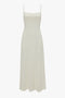 A full-length, sleeveless Exclusive Panelled Midi Cami Dress In Vanilla with thin shoulder straps in a solid white color, inspired by Victoria Beckham.