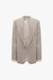 A beige Darted Sleeve Tailored Jacket In Sesame with a single button and wide lapels. The interior lining is visible, and the sleeves feature pink cuffs. This pure wool blazer by Victoria Beckham, which debuted on the SS24 runway, is showcased against a white background.