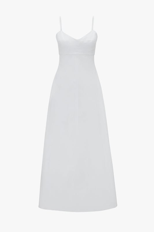 A white, floor-length summer dress with thin spaghetti straps, a fitted bodice, and a flared skirt exudes a bohemian vibe. The Cami Fit And Flare Midi In White by Victoria Beckham perfectly captures this essence.