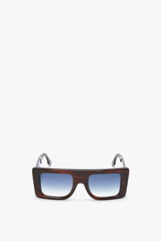 Rectangular sunglasses with a Brown Horn colourway and gradient blue lenses, shown against a white background, are the Victoria Beckham Oversized Frame Sunglasses In Brown Horn.