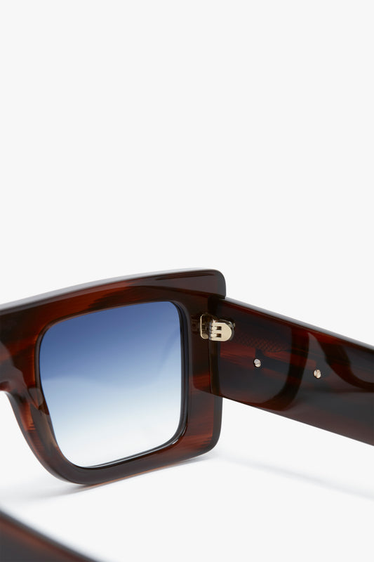 Close-up of Oversized Frame Sunglasses In Brown Horn by Victoria Beckham, showcasing the temple hinge and arm details on a plain white background.