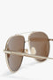 Close-up image of V Metal Pilot Sunglasses In Gold-Khaki with brown lenses, featuring the "Victoria Beckham" logo engraved on the arm and adjustable nose pads for a perfect fit.