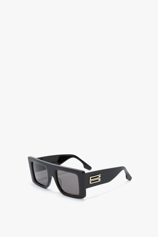 Rectangular black sunglasses with a bold oversized frame and dark lenses, featuring a sleek and modern metallic accent on the temples, like the Oversized Frame Sunglasses In Black by Victoria Beckham.