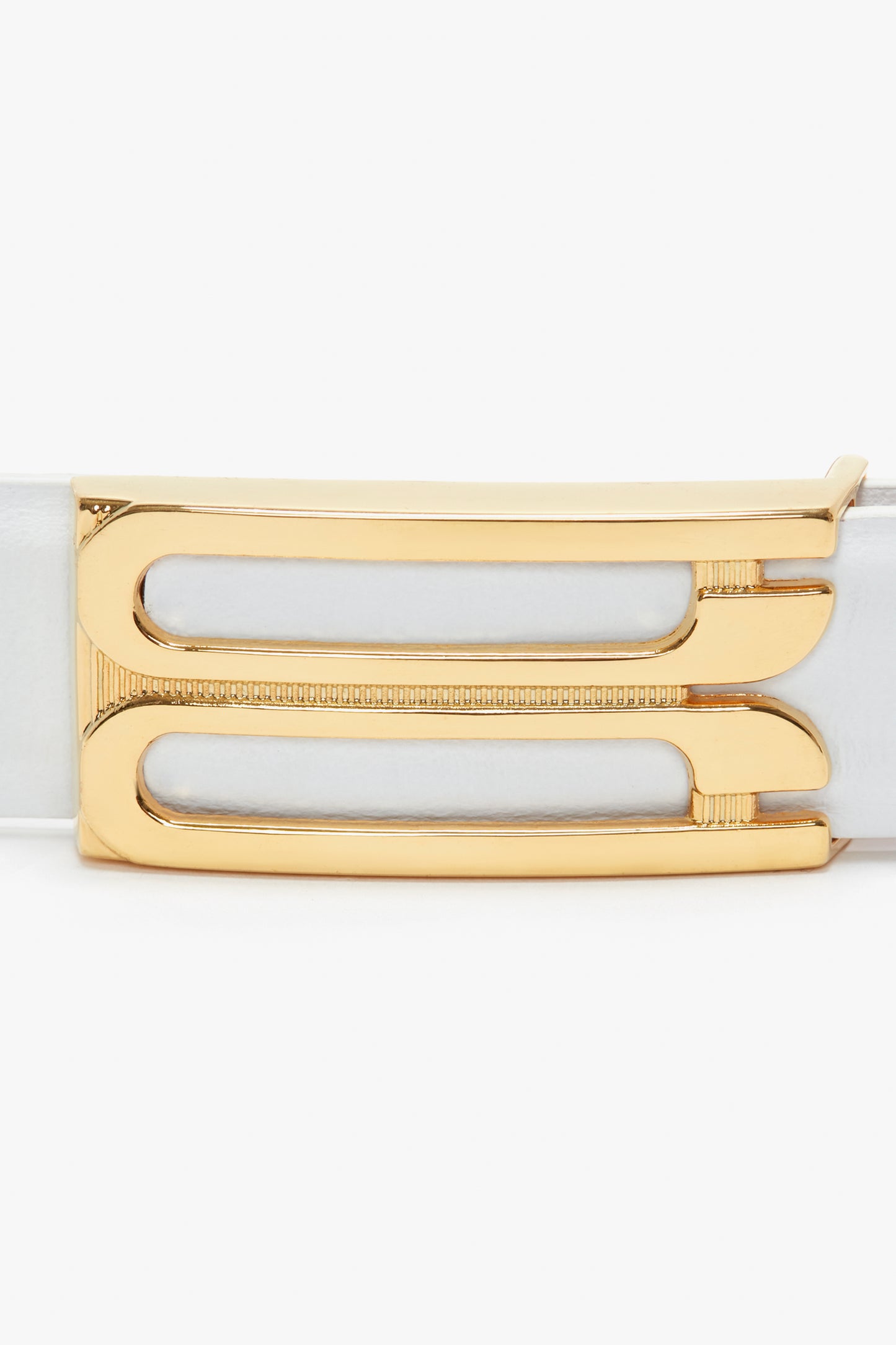 A close-up of a Victoria Beckham Frame Belt In White Leather in smooth calf leather with a rectangular gold buckle featuring dual horizontal cut-out designs.