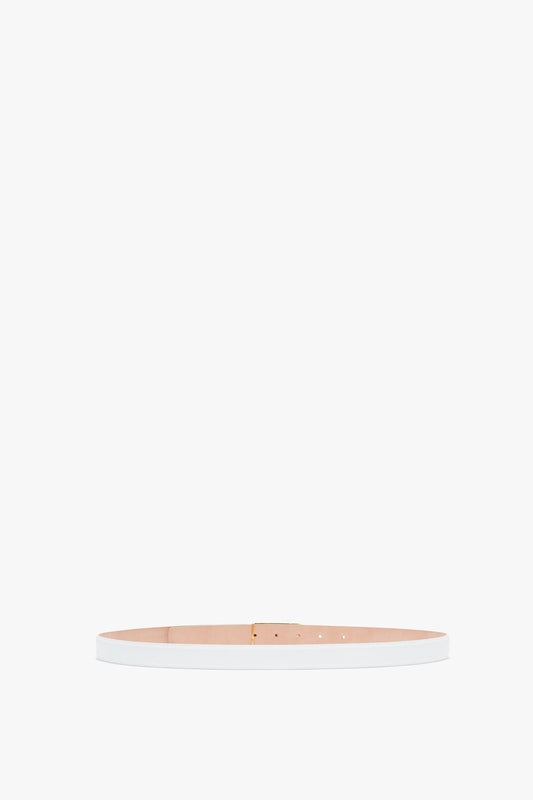 A slim, pale pink calf leather Exclusive Frame Belt In White Leather with gold hardware, displayed horizontally against a white background by Victoria Beckham.