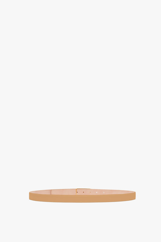 A Victoria Beckham wooden skateboard deck with gold hardware, displayed against a plain white background.