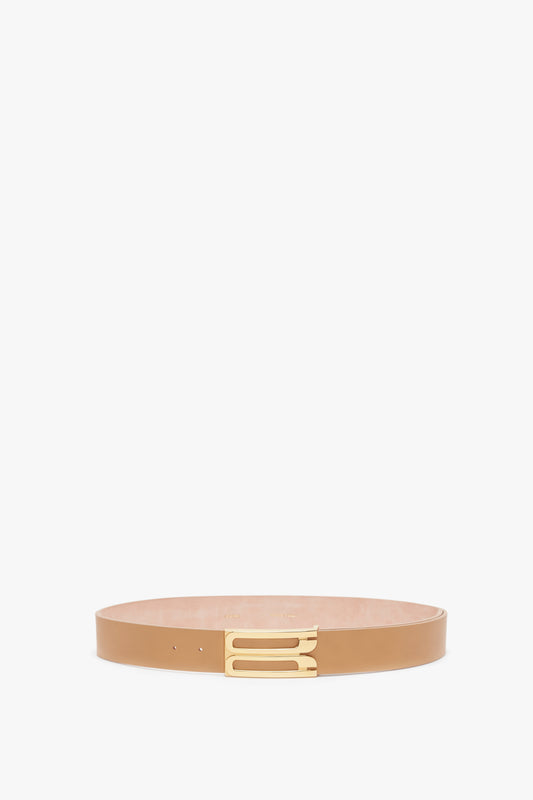 A Jumbo Frame Belt In Camel Leather by Victoria Beckham, with a minimalist gold buckle, displayed against a white background.